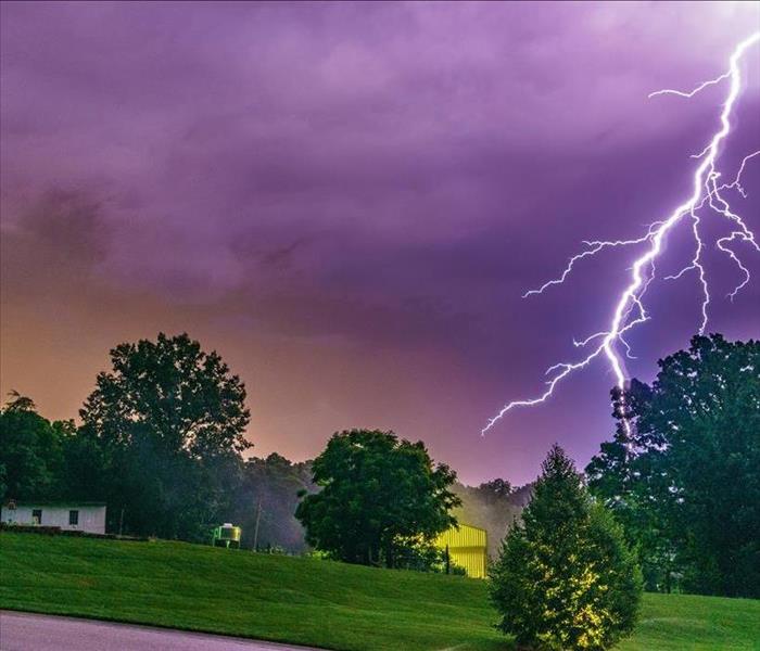 lightning strike in sky near home on ground; storm